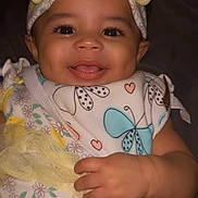 Naomi joined the competition — help win amazing prizes! baby, infant, smile, headband, bow, bib, butterfly, hand, toy, yellow, clothing, daisy, flower, cute, portrait, face, child, happy, closeup, toddler