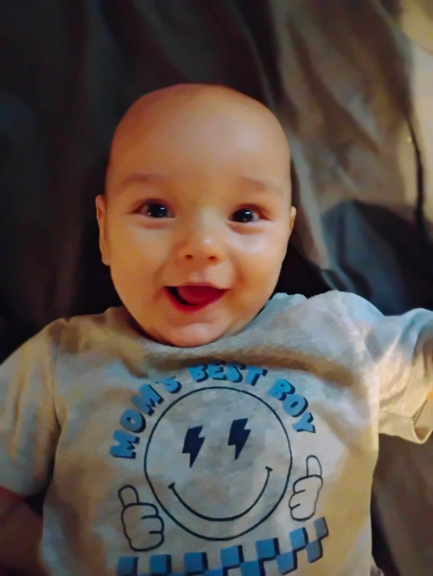 Kasson is registered to the contest to win money with this photo: baby, smiling, tshirt, child, happy, face, infant, portrait, young, person, cute, indoors, clothing, sleeve, skin, expression, joy, head, eyes, mouth