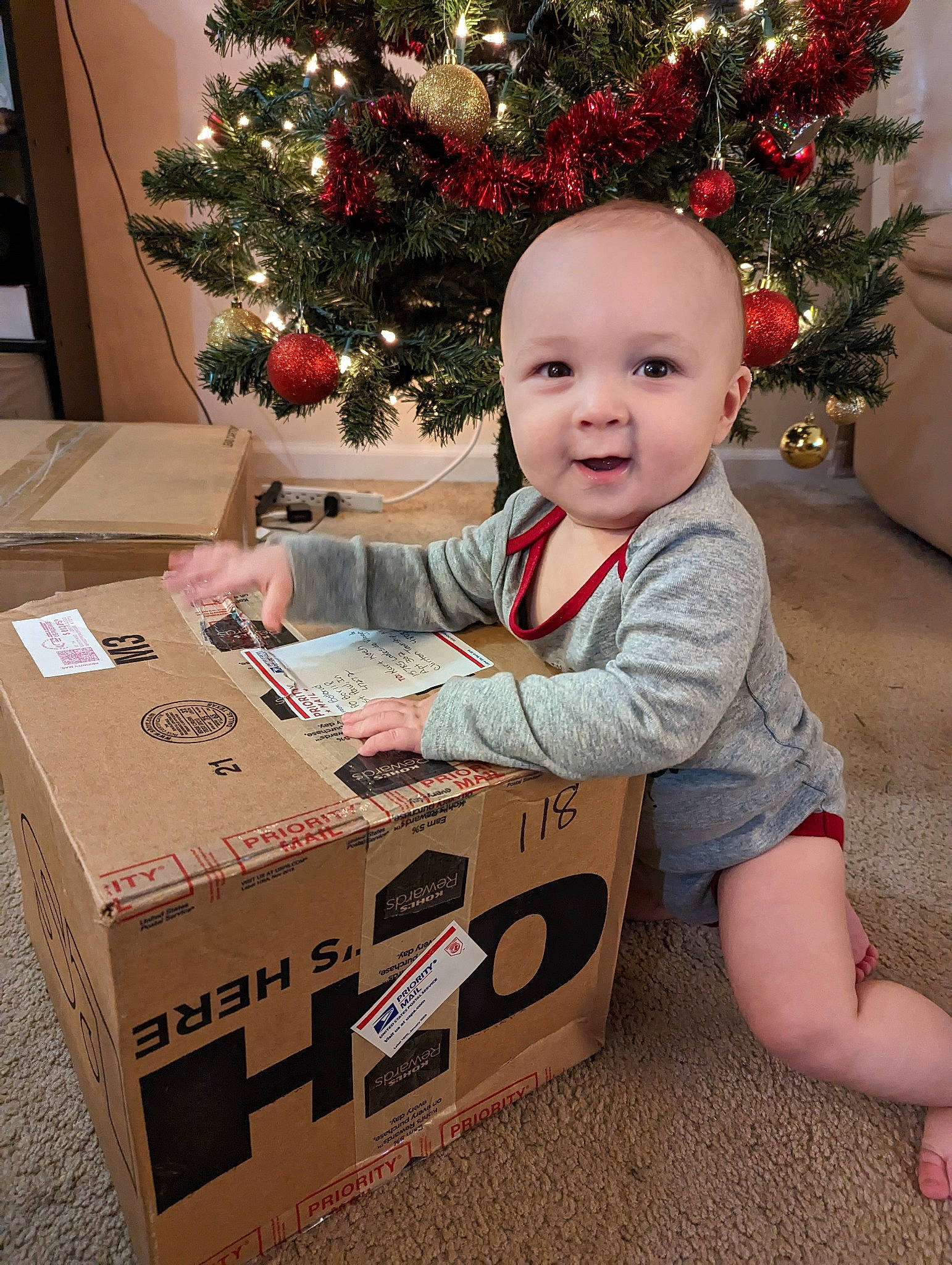 Kristian joined the competition — help win amazing prizes! baby, baby_toddler_clothing, box, cardboard, carton, child, christmas, christmas_decoration, christmas_ornament, christmas_tree, event, happy, holiday, holiday_ornament, packaging_and_labeling, packing_materials, person, shipping_box, sleeve, smile