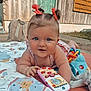 baby, infant, child, pigtails, bows, toy_phone, play_mat, outdoor, grass, wooden_wall, soft_toys, cute, smiling, face, hands, colorful, curious, portrait, toddler, young_child
