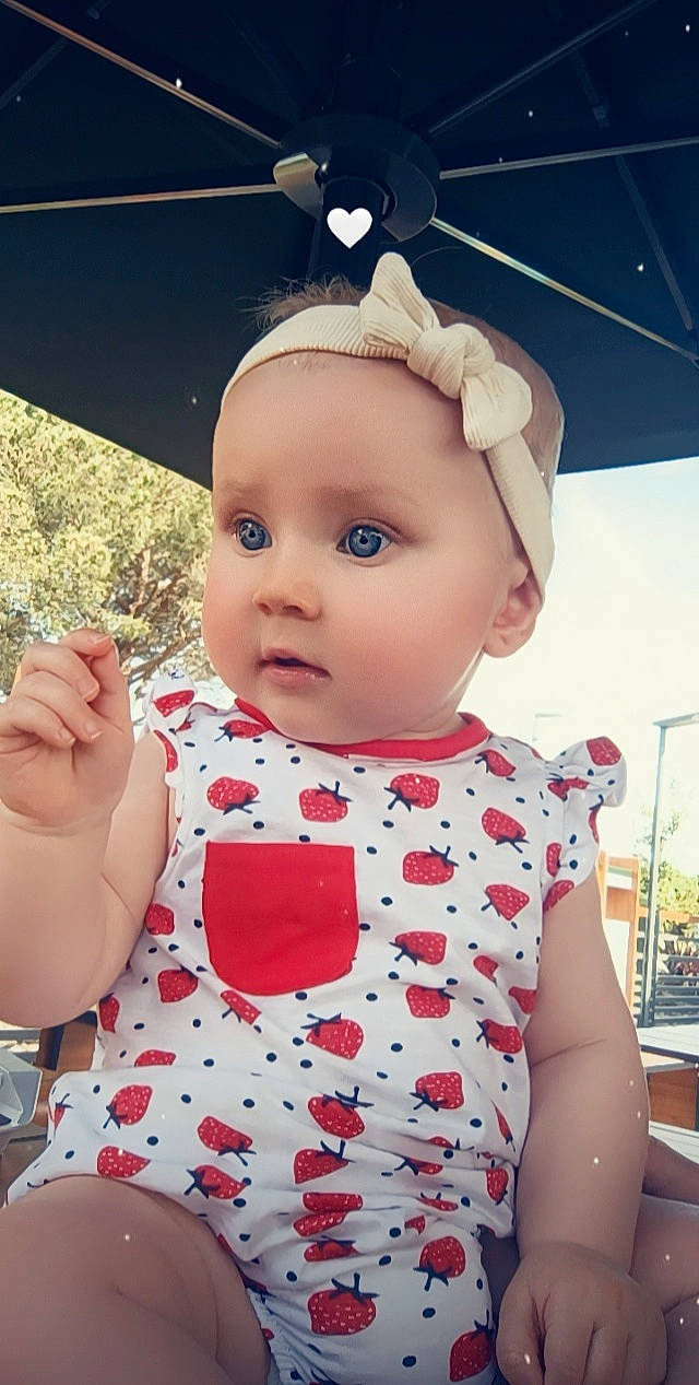 Victoria a rejoint le concours — aidez-le/la à gagner de superbes lots ! baby, baby_toddler_clothing, cap, child, dress, eyelash, eyewear, fun, grass, happy, headwear, lip, nose, pattern, person, pink, skin, sleeve, textile, toddler