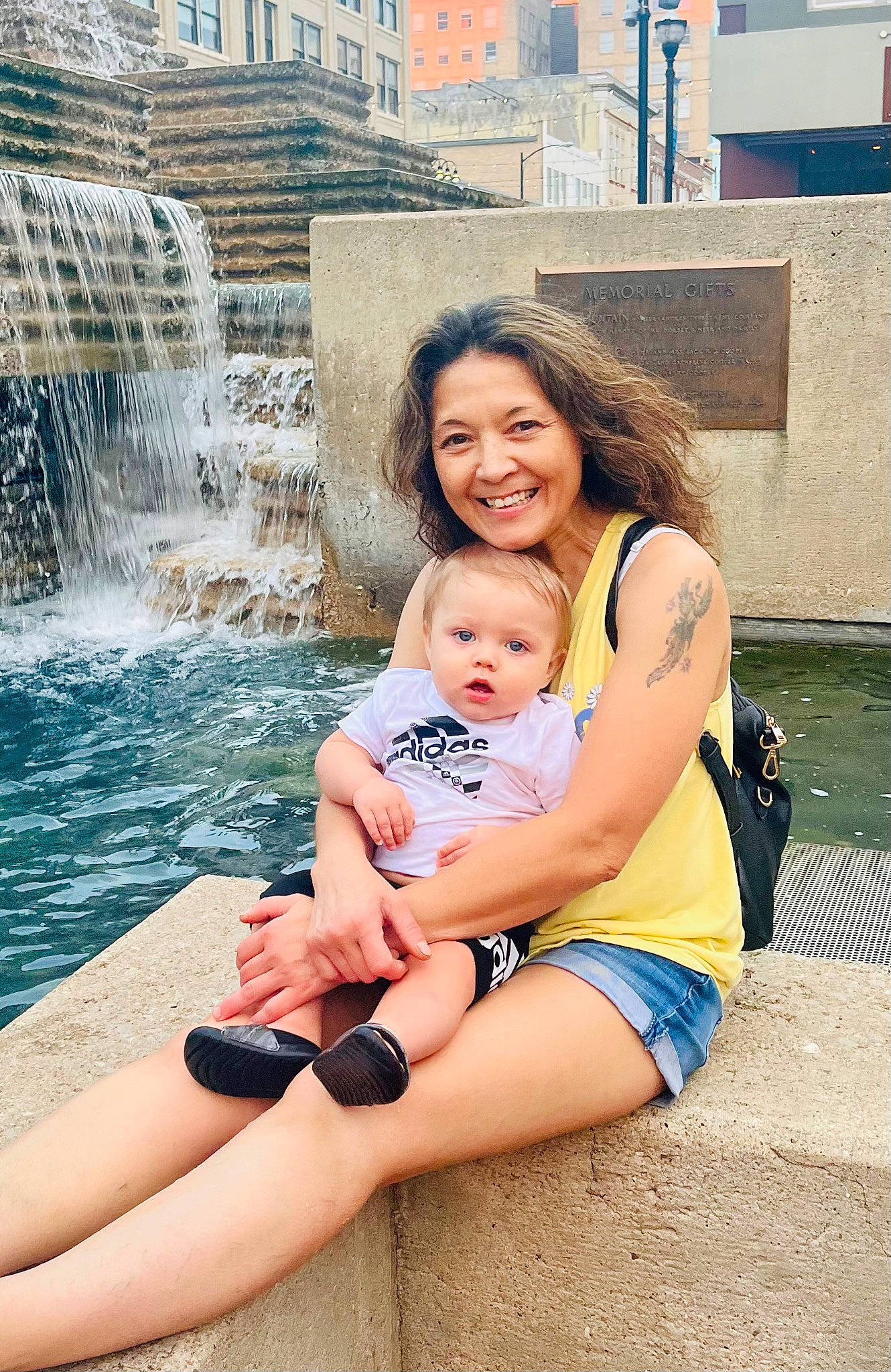 Jasper is registered to the contest to win money with this photo: beauty, child, foot, fountain, friendship, fun, happy, human_leg, interaction, joy, leisure, person, recreation, shorts, sitting, smile, spring, summer, thigh, toddler