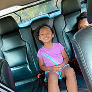Miracle joined the competition — help win amazing prizes! child, smile, car_interior, seat, purple_shirt, blue_crocs, happy, person, backseat, window, seatbelt, hair, footwear, casual_clothing, leather_seat, sunlight, daylight, two_children, seated, portrait