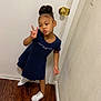 Miracle is registered to the contest to win money with this photo: child, girl, peace_sign, blue_dress, white_sneakers, indoor, wooden_floor, door, wall, hair_bun, posing, casual, young, fashion, smiling, standing, person, clothing, footwear, home