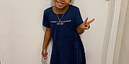 Legacy joined the competition — help win amazing prizes! child, girl, smile, peace_sign, dress, blue_dress, white_sneakers, standing, indoor, wooden_floor, door, hair_bun, necklace, happy, casual_clothing, floor, person, young, fashion, portrait