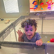 Arthur joined the competition — help win amazing prizes! toddler, child, playpen, bubbles, curly_hair, living_room, dog, television, cartoon, floor, window, light, toy, basketball, striped_shirt, person, home, interior, sleeping_dog, happy
