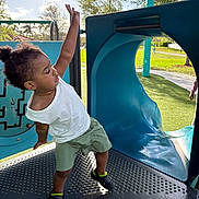 Jireh joined the competition — help win amazing prizes! toddler, child, playground, slide, outdoor, daylight, greenery, park, happy, active, casual_clothing, shorts, white_shirt, footwear, balance, play, young_child, curly_hair, fun, summer