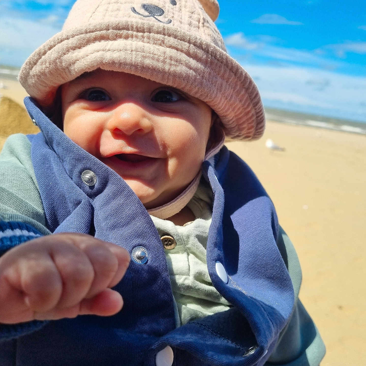 Sammarveer is registered to the contest to win money with this photo: baby, beach, bodypart, cap, clothing, coast, coat, face, finger, hand, hat, head, jacket, nature, outdoors, person, photography, portrait, sea, shoreline