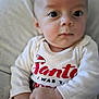 baby, blur, child, clothing, cute, expression, eyes, face, hands, holiday, indoor, infant, onesie, person, portrait, santa, sitting, skin, soft, young