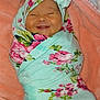 Liliana is registered to the contest to win money with this photo: baby, infant, smile, blanket, headband, floral_pattern, wrapped, cute, happy, newborn, soft_texture, fabric, portrait, child, face, cozy, pink, green, person, indoors