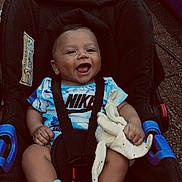 Kayden participe au concours pour gagner de l'argent avec cette photo : baby, car_seat, smiling, nike_shirt, blue_socks, plush_toy, happy, child, infant, seat_belt, outdoor, toy, cute, clothing, person, face, portrait, sitting, baby_clothes, footwear
