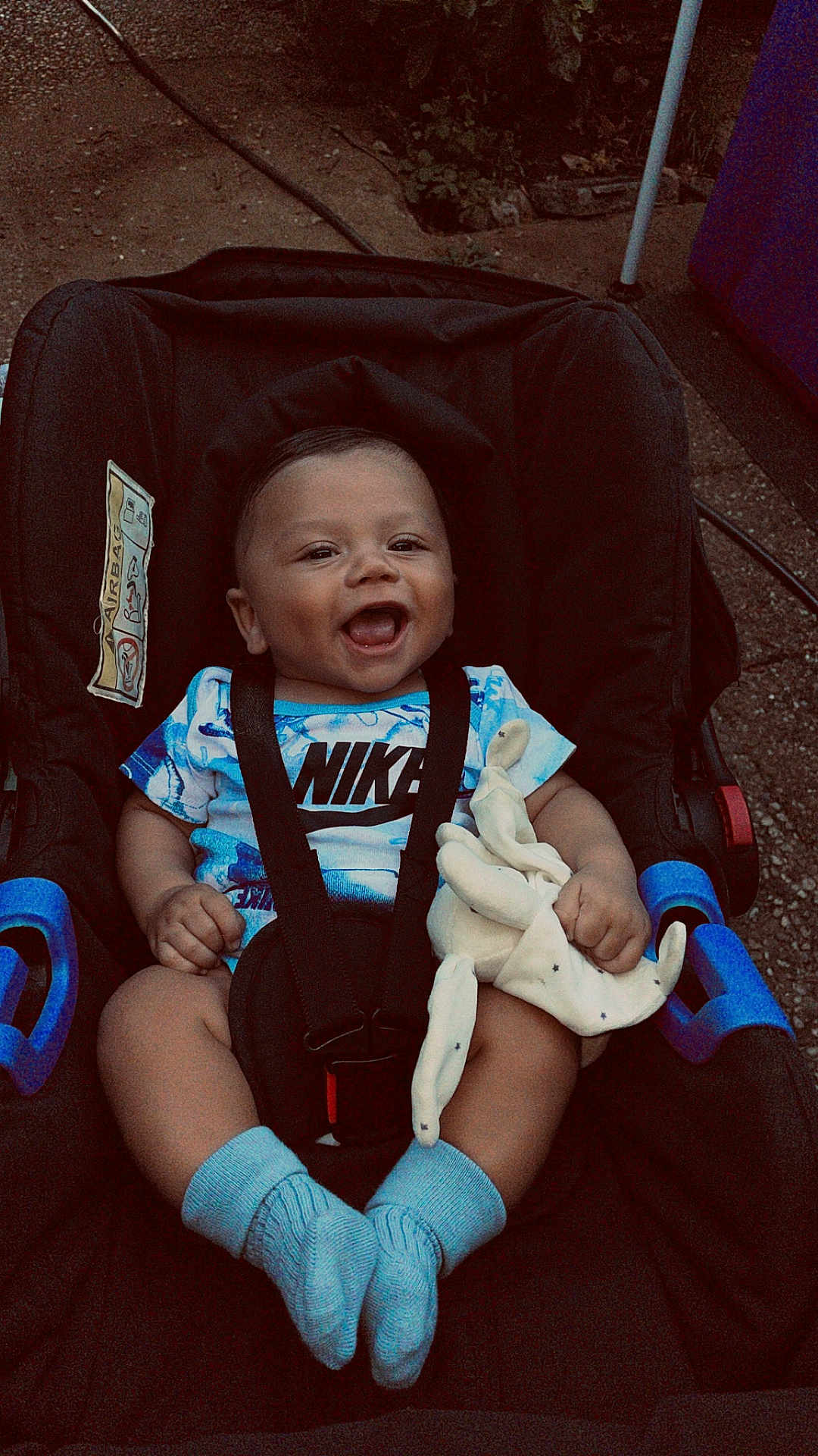 Kayden participe au concours pour gagner de l'argent avec cette photo : baby, car_seat, smiling, nike_shirt, blue_socks, plush_toy, happy, child, infant, seat_belt, outdoor, toy, cute, clothing, person, face, portrait, sitting, baby_clothes, footwear