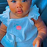 Mulani is registered to the contest to win money with this photo: baby, infant, child, portrait, car_seat, seated, blue_outfit, frills, ruffles, bib, clothing, vehicle, interior, seatbelt, face, eyes, looking_at_camera, photograph, smartphone_screenshot, colorful