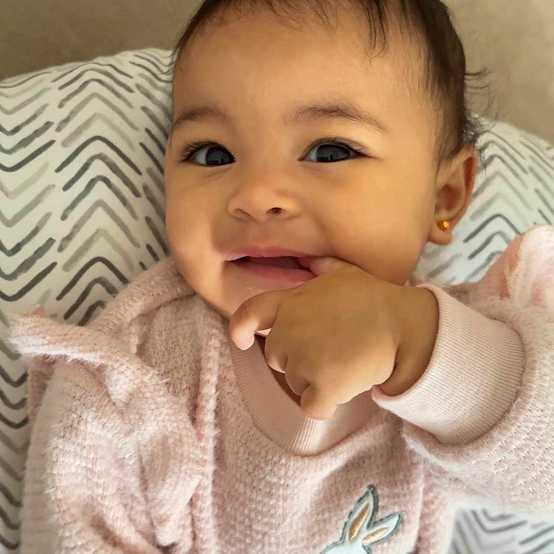 Azaelle joined the competition — help win amazing prizes! baby, child, cozy, cushion, cute, earring, face, fingertip_in_mouth, hand, happy, human, indoor, infant, pink_sweater, portrait, rabbit_design, smiling, soft_texture, warm_clothing, zigzag_pattern