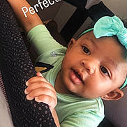 Hazellbelle is registered to the contest to win money with this photo: baby, bow, child, curious, cute, doll, face, green_shirt, hands, headband, indoor, infant, peeking, person, playpen, portrait, smiling, soft_toys, toy, young_child