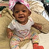Hazellbelle joined the competition — help win amazing prizes! baby, child, smiling, sitting, bow, headband, pink, orange_socks, floral_pants, white_shirt, bed, pillows, blanket, indoors, cute, happy, portrait, infant, clothing, person