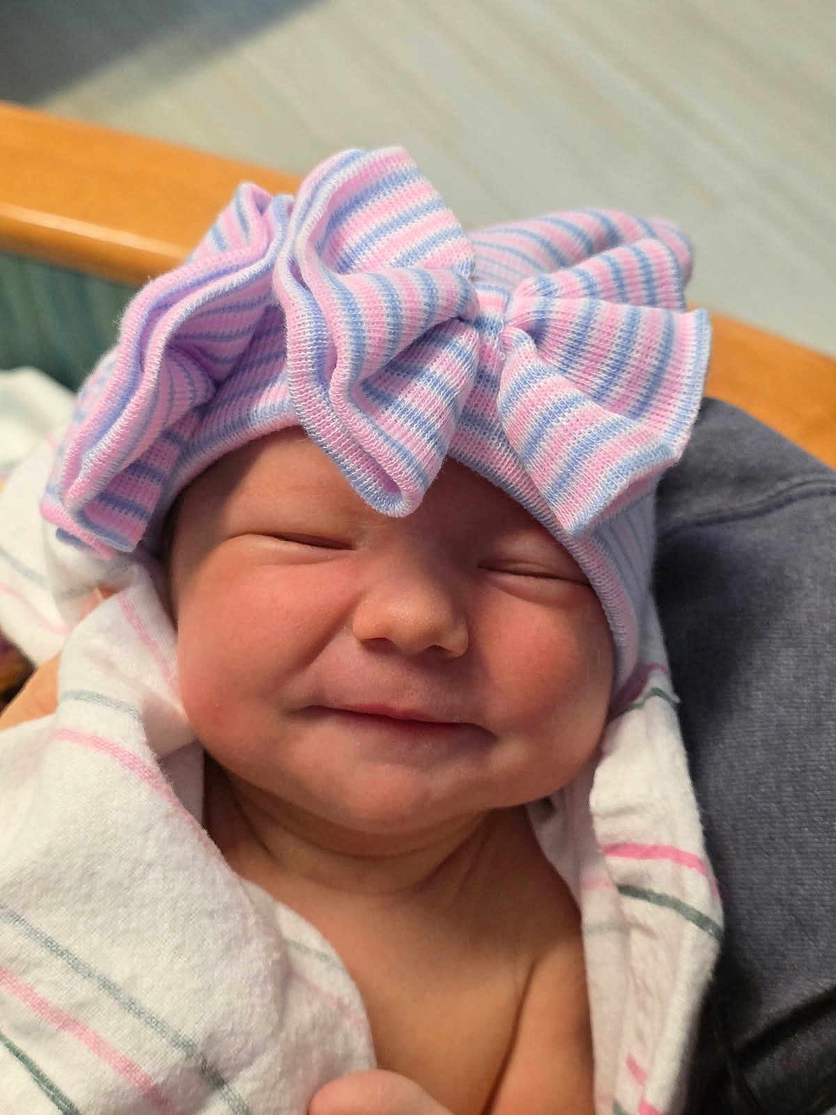 Isla is registered to the contest to win money with this photo: newborn, baby, smiling, hat, bow, striped, blanket, wrapped, infant, cute, face, headwear, sleepy, hospital, person, portrait, soft, pink, blue, newborn_baby