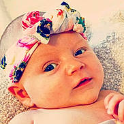 Esmeray joined the competition — help win amazing prizes! baby, child, closeup, cute, expression, eyes, face, floral, hand, headband, indoors, infant, innocent, lying_down, person, portrait, skin, soft, texture, young