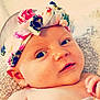 baby, child, closeup, cute, expression, eyes, face, floral, hand, headband, indoors, infant, innocent, lying_down, person, portrait, skin, soft, texture, young