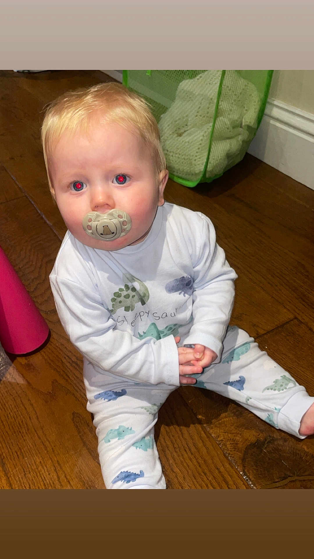 Cobie Lewis joined the competition — help win amazing prizes! toddler, child, pacifier, pajamas, dinosaur_pattern, wooden_floor, indoor, laundry_basket, clothing, sitting, curious, blond_hair, baby, flooring, long_sleeve, pants, person, home, infant, casual
