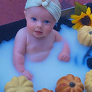 Nevaeh joined the competition — help win amazing prizes! arm, baby, bathtub, black_cloth, blue_eyes, child, cute, decor, hand, head_wrap, indoors, infant, milky_bath, orange, portrait, pumpkins, skin, smile, sunflowers, yellow