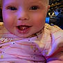 Nevaeh is registered to the contest to win money with this photo: baby, cheeks, child, close_up, cute, cute_expression, drool, face, hand, happy, indoor, infant, patterned_shirt, person, pink_clothing, portrait, skin, smiling, warm_lighting, young