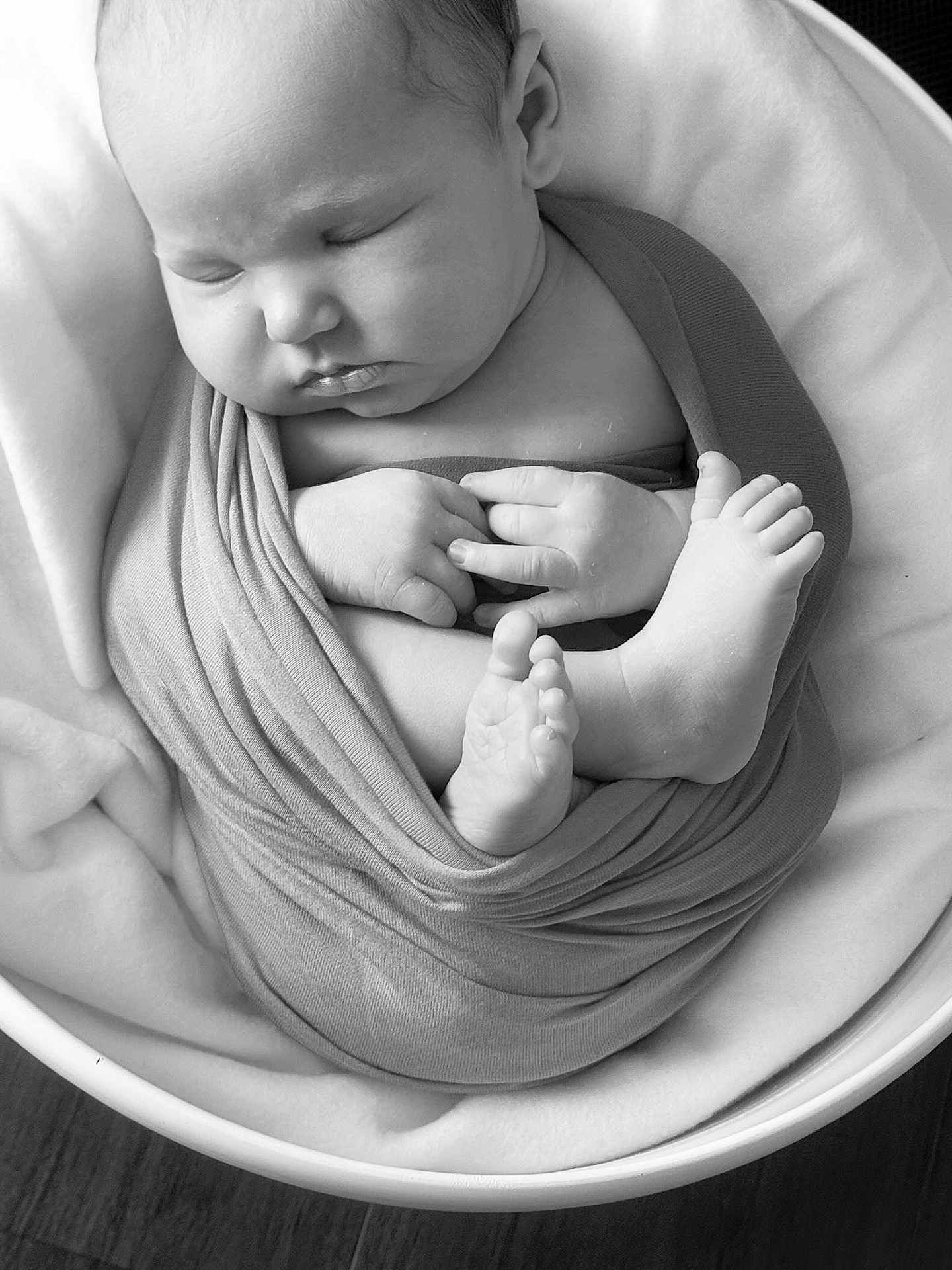 Noah a rejoint le concours — aidez-le/la à gagner de superbes lots ! baby, newborn, sleeping, swaddled, blanket, feet, hands, face, infant, soft, cozy, wrapped, peaceful, cute, monochrome, black_and_white, portrait, resting, bowl, child