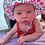 baby, bodypart, bonnet, cap, clothing, dress, face, finger, hand, hat, head, person, photography, portrait, purple, quilt, sitting, summer, sunhat, swimwear
