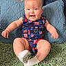 baby, child, smiling, onesie, sitting, indoor, pillow, rug, happy, face, cute, infant, legs, sock, blue, red, green, pattern, celebration, person