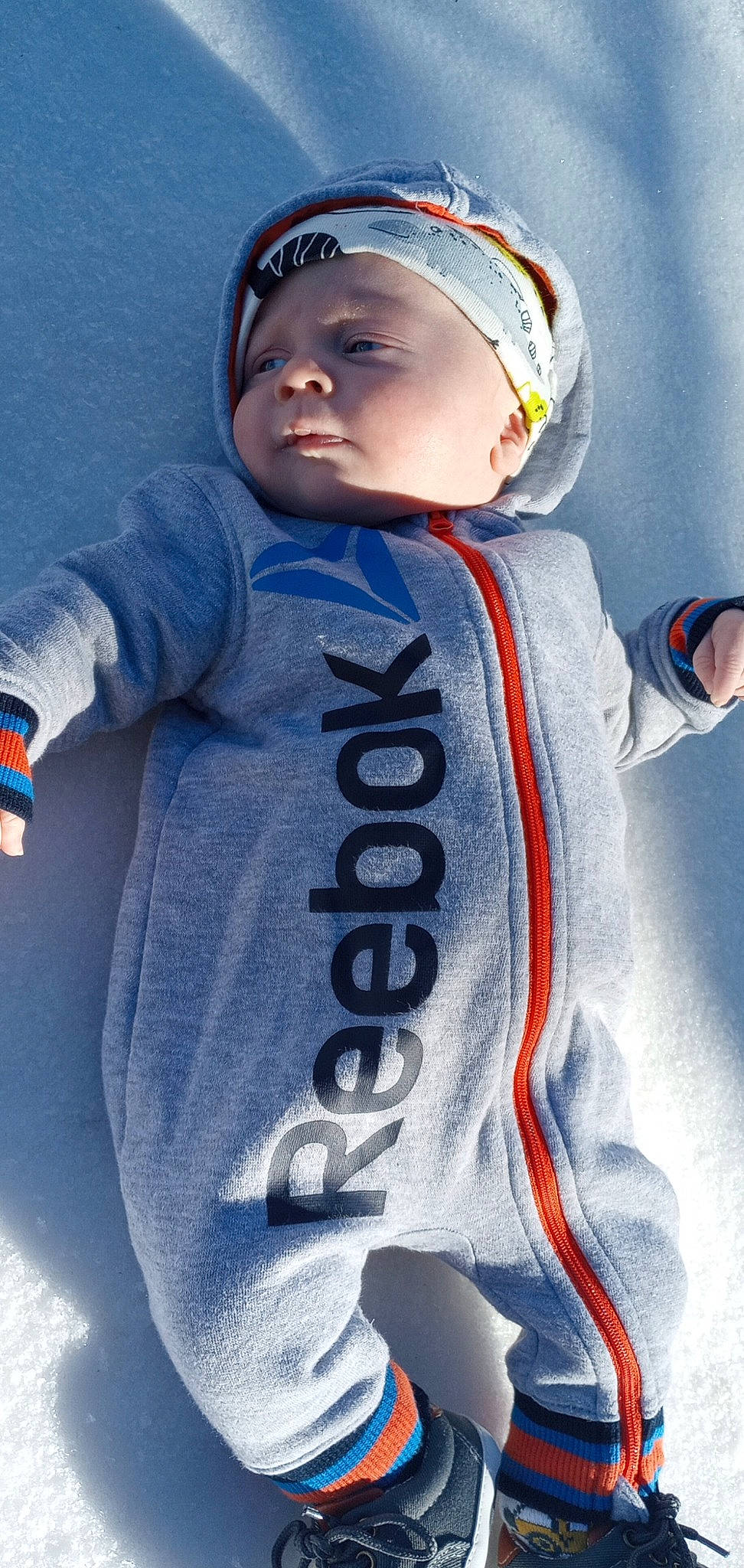 Everett is registered to the contest to win money with this photo: arm, azure, baby, baby_products, baby_toddler_clothing, baseball_cap, cap, child, cool, electric_blue, freezing, gesture, happy, headgear, jersey, personal_protective_equipment, sleeve, toddler, white, winter