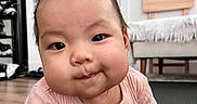 Haylen joined the competition — help win amazing prizes! baby, bag, chair, child, curious, cute, expression, face, floor, furniture, hands, home, indoor, infant, mat, person, pink_clothing, smile, wooden_floor, young