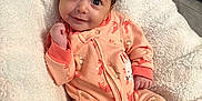 Adalina is registered to the contest to win money with this photo: baby, infant, onesie, smile, cute, blanket, soft, indoor, floor, tile, footwear, baby_booties, face, person, child, happy, cozy, animal_print, lying_down, wooden_cabinet