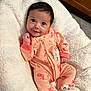 Adalina is registered to the contest to win money with this photo: baby, infant, onesie, smile, cute, blanket, soft, indoor, floor, tile, footwear, baby_booties, face, person, child, happy, cozy, animal_print, lying_down, wooden_cabinet