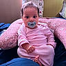 Freya joined the competition — help win amazing prizes! baby, infant, pacifier, pink_clothing, cushion, indoor, blanket, bed, child, cute, portrait, person, relaxing, soft_lighting, young, small_hands, facial_expression, home, seated, comfort