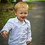 toddler, child, blond_hair, white_shirt, shorts, smiling, outdoor, park, pathway, walking, happy, young_child, boy, casual_clothing, nature, daylight, playful, cute, portrait, person