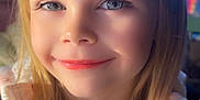 Mariah is registered to the contest to win money with this photo: child, smile, face, portrait, blonde_hair, blue_eyes, jacket, pink_shirt, indoor, warm_light, happy, young, person, clothing, casual, closeup, cute, childhood, girl, hair