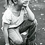 child, girl, smiling, crouching, jeans, white_shirt, pony_tail, outdoor, pavement, leaves, casual_clothing, happy, portrait, young, nature, playful, daylight, monochrome, black_and_white, person