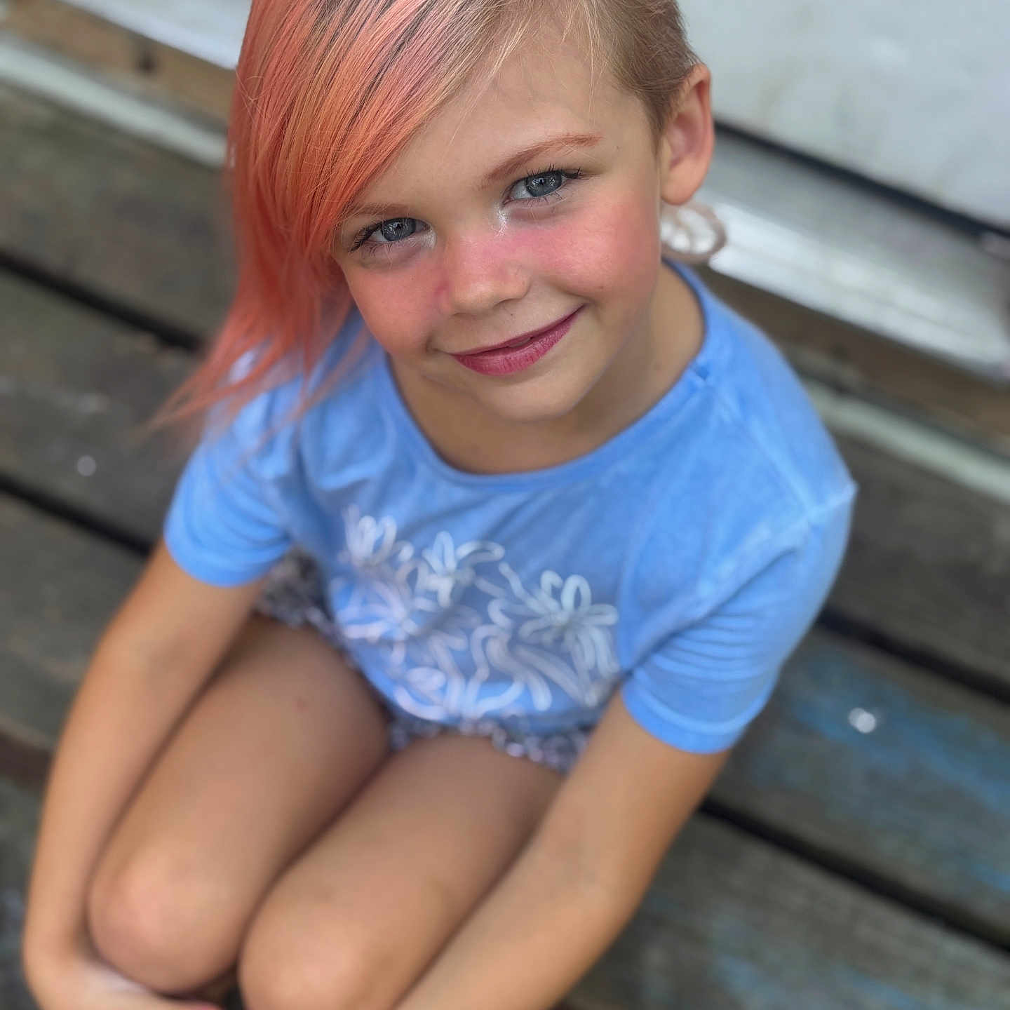 Mariah joined the competition — help win amazing prizes! barefoot, blue_eyes, blue_shirt, casual, child, crossed_legs, daylight, face, happy, natural_light, outdoor, peach_hair, person, portrait, shorts, sitting, smiling, summer, wooden_deck, youth
