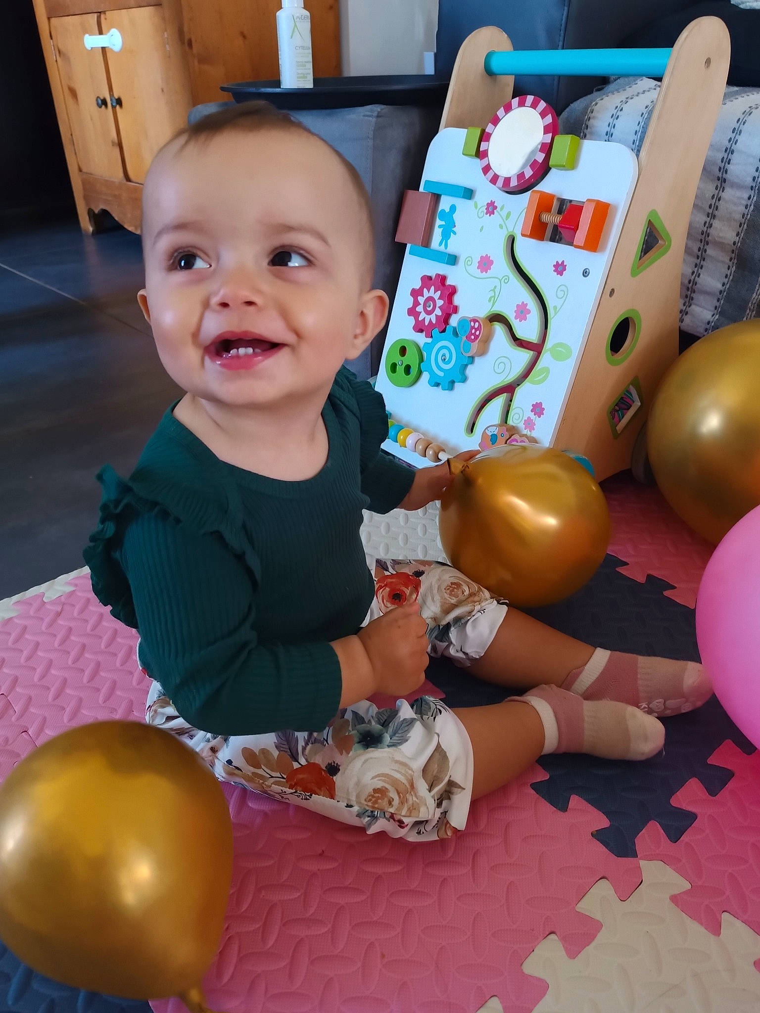 Elya participe au concours pour gagner de l'argent avec cette photo : baby, baby_playing_with_toys, baby_toddler_clothing, balloon, chair, child, event, flooring, fun, happy, human_body, joy, party, party_supply, person, play, room, sitting, smile, toddler