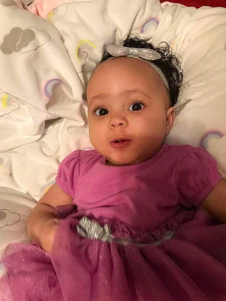 Symphony is registered to the contest to win money with this photo: baby, baby_toddler_clothing, cheek, chin, comfort, dress, eye, eyebrow, eyelash, flash_photography, happy, iris, lip, mouth, person, pink, purple, skin, sleeve, textile