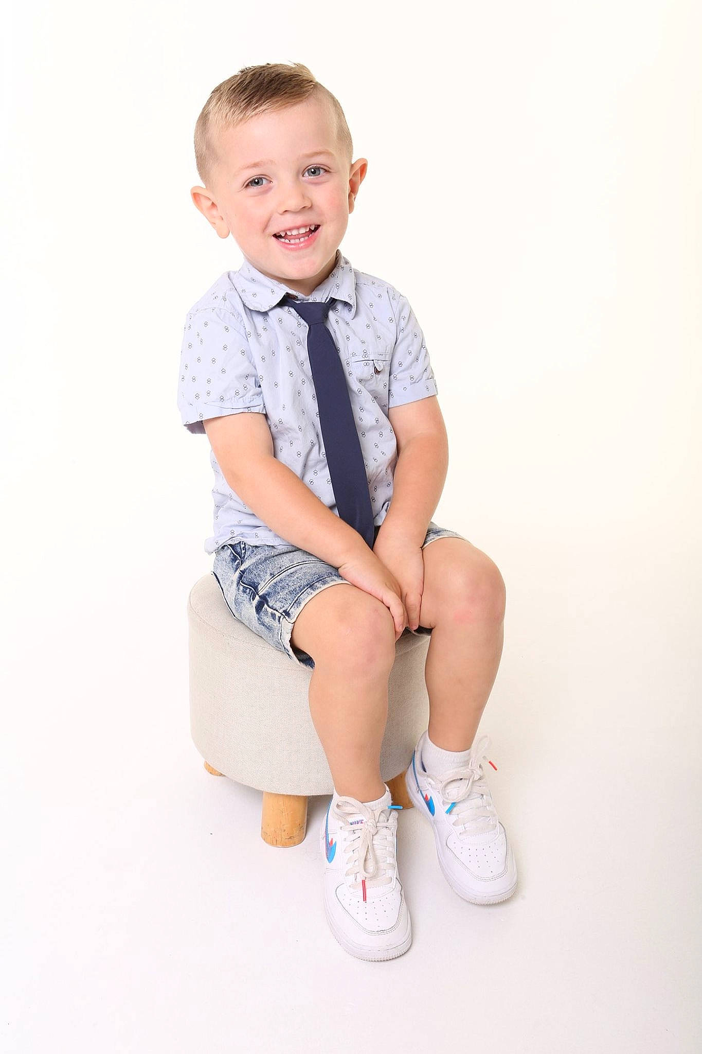 Nixon is registered to the contest to win money with this photo: baby, blue, child, child_model, footwear, joy, knee, leg, person, photo_shoot, photography, portrait, portrait_photography, product, shoe, sitting, sleeve, smile, standing, t_shirt