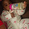 Ciara joined the competition — help win amazing prizes! baby, bottle, milk, onesie, cherry_pattern, pink_bow, infant, sleepwear, cute, drinking, child, young, portrait, relaxing, indoor, person, hand, face, baby_girl, comfort