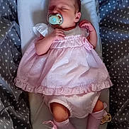 Rose is registered to the contest to win money with this photo: baby, newborn, pacifier, pink_dress, pink_socks, baby_nest, gray_blanket, stars_pattern, sleeping, infant, cute, resting, child, soft_fabric, cozy, lying_down, peaceful, small, portrait, indoors
