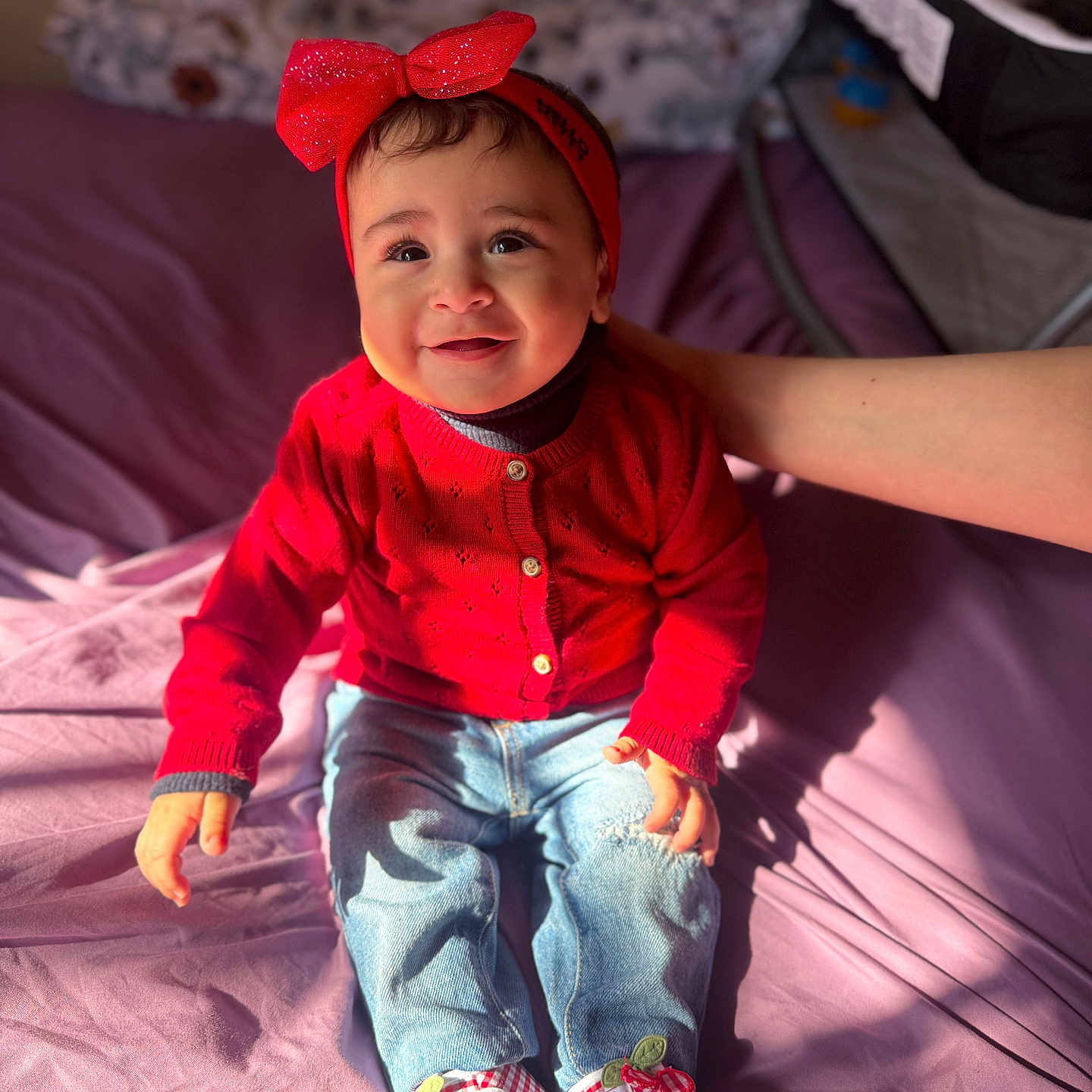 Zainab Samhan joined the competition — help win amazing prizes! baby, bed, casual, child, clothing, cute, footwear, hand, happy, headband, indoor, infant, jeans, person, portrait, red_sweater, shoes, sitting, smiling, sunlight