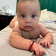 Jaziel is registered to the contest to win money with this photo: baby, infant, face, arm, hand, bracelet, bed, bedding, expression, skin, person, indoor, curious, closeup, portrait, young_child, sleepwear, blanket, head, looking