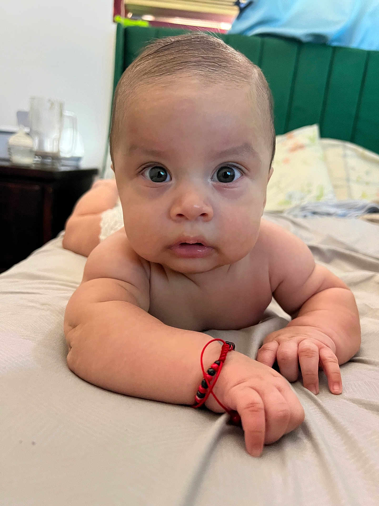 Jaziel is registered to the contest to win money with this photo: baby, infant, face, arm, hand, bracelet, bed, bedding, expression, skin, person, indoor, curious, closeup, portrait, young_child, sleepwear, blanket, head, looking
