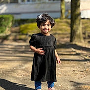 Faiha participe au concours pour gagner de l'argent avec cette photo : child, smiling, outdoor, dress, black_dress, blue_leggings, pink_sneakers, curly_hair, hair_accessory, sunny, daylight, shadow, sidewalk, nature, tree, person, cute, happy, portrait, young