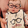 Alexis participe au concours pour gagner de l'argent avec cette photo : baby, glasses, bib, harry_potter, beard, shirtless, man, chain_necklace, dinosaur_pattern, curious, drool, orange_pants, holding, portrait, indoor, person, cute, child, face, hands