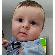 Alexis a rejoint le concours — aidez-le/la à gagner de superbes lots ! baby, child, face, hand, person, indoor, blue_clothing, curious, chubby_cheeks, portrait, closeup, human, skin, eyebrows, eyes, nose, mouth, hair, infant, holding