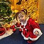 child, toddler, christmas_dress, red_dress, holiday, festive, christmas_tree, ornaments, golden_lights, pigtails, curious, indoor, decorations, holiday_season, celebration, cute, smiling, festive_attire, holiday_spirit, red_shoes